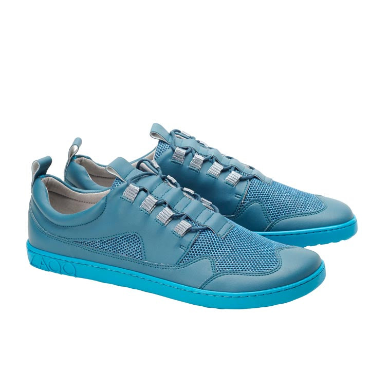 Ein elegantes und sportliches Paar türkisfarbener QARLY-Sneaker von ZAQQ mit Schnürdesign und blauen Mesh-Details vor schlichtem weißen Hintergrund.