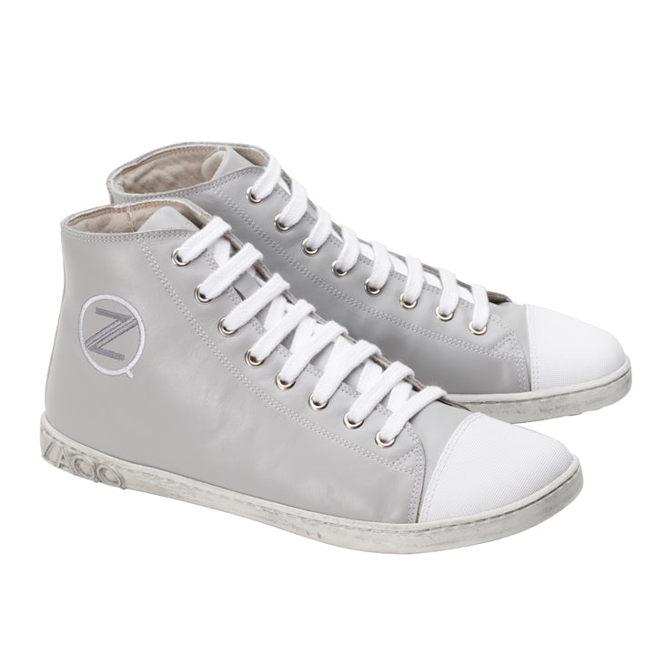 Die stylischen CHUQQS Grey High-Top-Sneaker von ZAQQ zeichnen sich durch ein markantes Z-Logo und eine dezent abgenutzte Sohle aus. Sie sind aus Nappaleder gefertigt, haben weiße Zehenkappen und Schnürsenkel und bieten eine elegante Mischung aus Komfort und Stil.