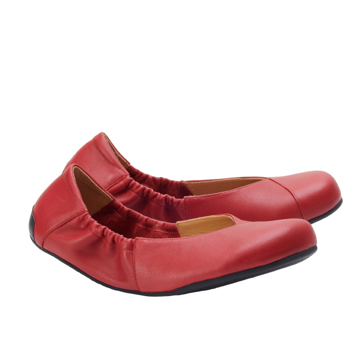 Die Ballerinas MAIQA Red von ZAQQ sind aus weichem Nappaleder gefertigt und verfügen über elastische Seitenteile für einen bequemen Sitz. Ihr minimalistisches Design mit schwarzer Sohle kommt vor einem schlichten weißen Hintergrund elegant zur Geltung.