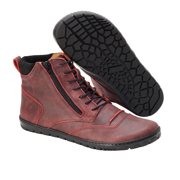 Wir präsentieren den PARQER Red von ZAQQ: ein Paar rote High-Top-Sneaker aus Premium-Nappaleder mit markanten schwarzen ZAQQ Outdoorsohlen. Ein Sneaker steht aufrecht, um den seitlichen Reißverschluss und die Schnürdetails hervorzuheben, während der andere angewinkelt ist, um das aufwendige Profilmuster zu zeigen. Diese Sneaker haben eine strukturierte Oberfläche mit einem dezent abgenutzten Look.