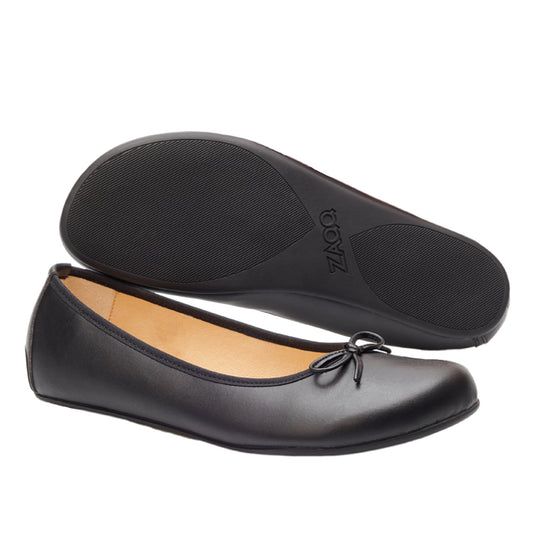 Wir präsentieren die LOOQ Vegan Black Ballerinas von ZAQQ: ein stilvolles Paar mit einer dezenten Schleife auf der Vorderseite. Ein Schuh steht aufrecht und betont sein elegantes Design, während der andere auf der Seite liegt und die strukturierte Sohle und das atmungsaktive Material zur Schau stellt, die einen idealen Barfußkomfort bieten.