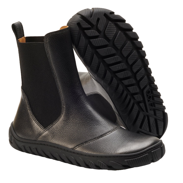 Ein Paar stylische schwarze Chelsea-Boots ZAQQ ELASTIQ, fachmännisch aus schwarzem Leder gefertigt, mit elastischen Seiteneinsätzen. Ein Boot steht aufrecht und zeigt die Vorder- und Seitenansicht, während der andere eine strukturierte Sohle aufweist, die das minimalistische Design hervorhebt.