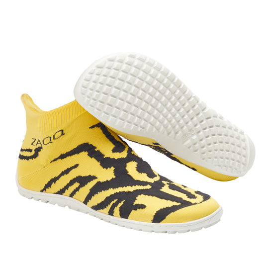 Die ZAQQ SOQQ Tiger Yellow Schuhe bestechen durch ein auffälliges Design mit schwarzen abstrakten Streifen und weißen Sohlen, die sowohl die Sohle als auch die Seitendetails hervorheben. Diese knöchelhohen Barfußschuhe bieten eine flexible, sockenähnliche Passform und einen strukturierten Griff für maximalen Komfort.