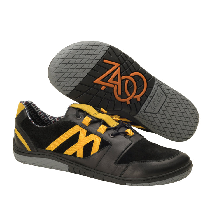 Die schwarzen QENDRIQ-Sneaker von ZAQQ zeichnen sich durch ein topaktuelles Design mit auffälligen schwarzen und gelben Akzenten und grauen Gummisohlen aus. Die Sohlen sind mit einem Dreiecksmuster und dem Logo der Marke verziert. Diese Sneaker sind so gestaltet, dass sie ein Profil neben der Sohle der anderen Seite zeigen und so mühelos den lässigen Stil unterstreichen.