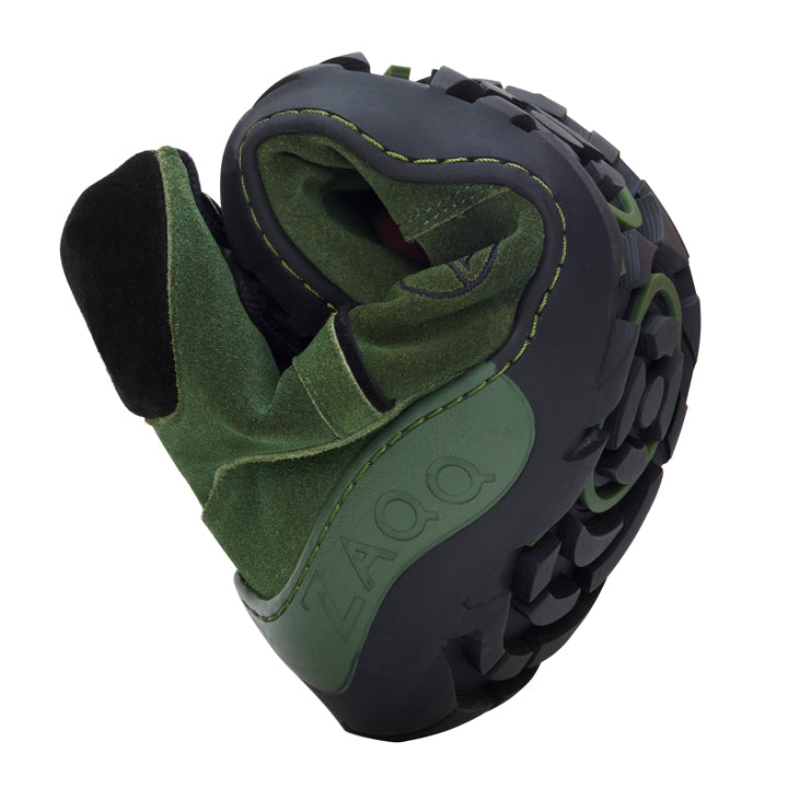 Der TREQ Green Waterproof von ZAQQ ist ein grün-schwarzer Schuh mit flexibler Sohle, die sich leicht in eine kompakte Form drehen lässt. Dieser Outdoor-Barfußschuh trägt den Markennamen ZAQQ auf der Seite und verfügt über die robusten, strukturierten Profile der ZAQQ TERRA Sohle für verbesserten Halt.