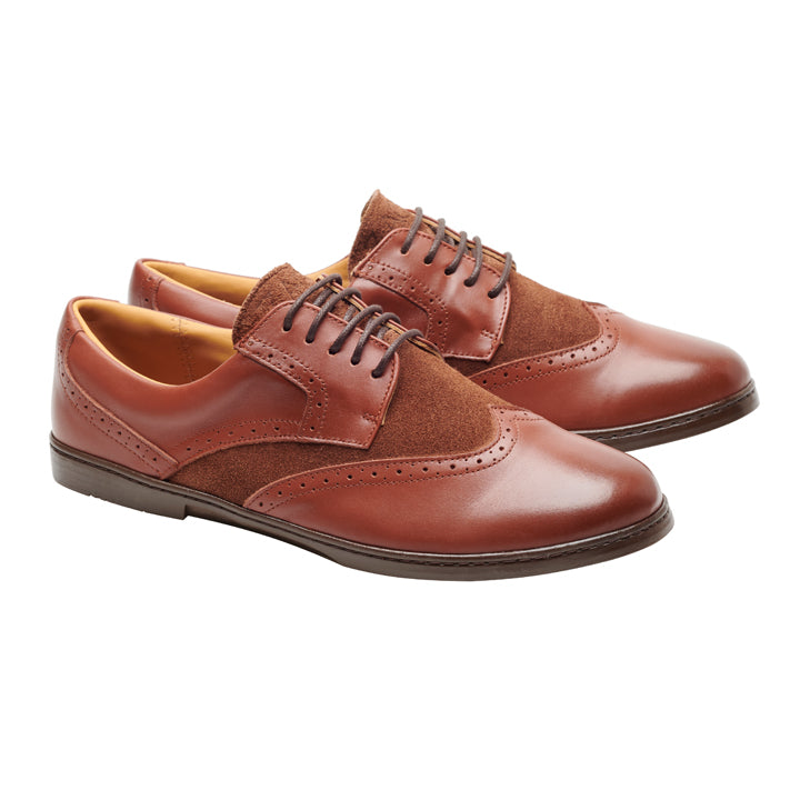 Ein Paar BRIQ Brogue Antique Cognac-Schuhe von ZAQQ, hergestellt aus braunem Kalbsleder und Wildleder, entworfen als Oxford-Business-Schuhe mit Schnürsenkeln und Brogue-Details. Das polierte Finish wird durch die abgewinkelte Positionierung hervorgehoben und zeigt sich sowohl von der Seite als auch von vorne.