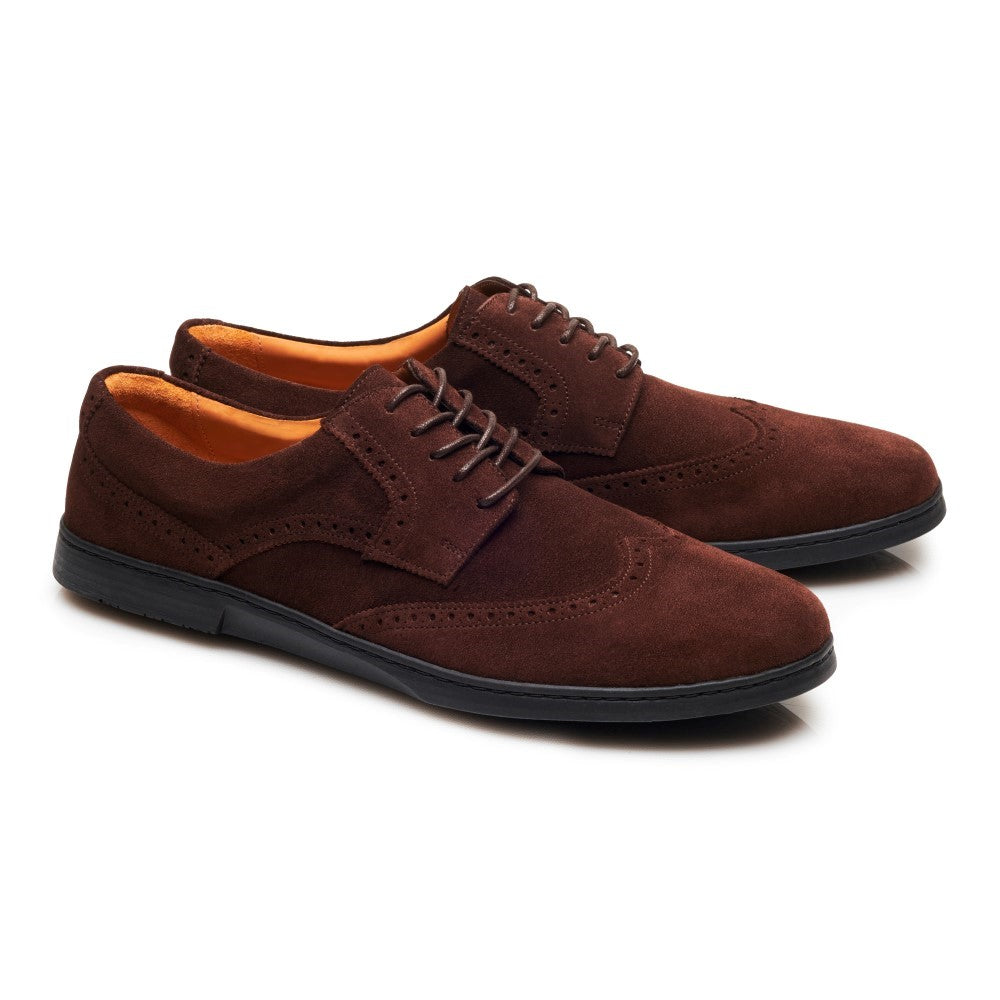 Ein Paar BRIQ Brogue Velours Brown von ZAQQ mit schwarzer Sohle. Diese klassischen Brogues verfügen über einen Schnürverschluss und ein orangefarbenes Innenfutter, elegant nebeneinander auf weißem Hintergrund präsentiert.