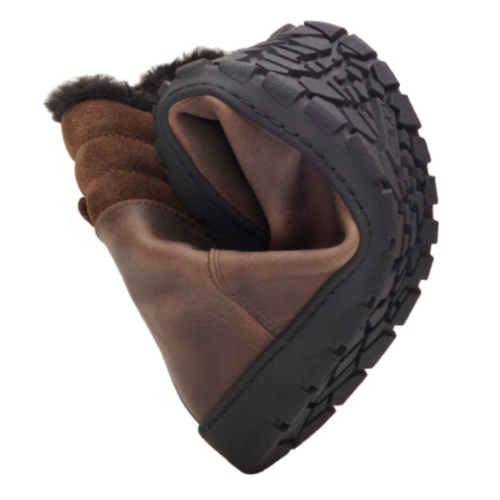 Der wasserdichte Stiefel QRAC Dark Brown von ZAQQ mit einem geschmeidigen Obermaterial aus braunem Leder und einer schwarzen Gummisohle ist in der Mitte gebogen, um seine Flexibilität hervorzuheben. Er verfügt über ein oben sichtbares Fellfutter, das sowohl Komfort als auch Wärme bietet und wasserdicht für vielseitige Abenteuer ist.