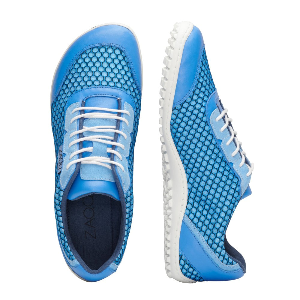 Ein Paar TOQIO Blue-Sneaker von ZAQQ aus atmungsaktivem Mesh-Gewebe mit weißen Schnürsenkeln und glatten weißen Sohlen. Ein Schuh ist von oben zu sehen, um das Design des Obermaterials hervorzuheben, während der andere seitlich positioniert ist, um die strukturierte Sohle zu präsentieren.