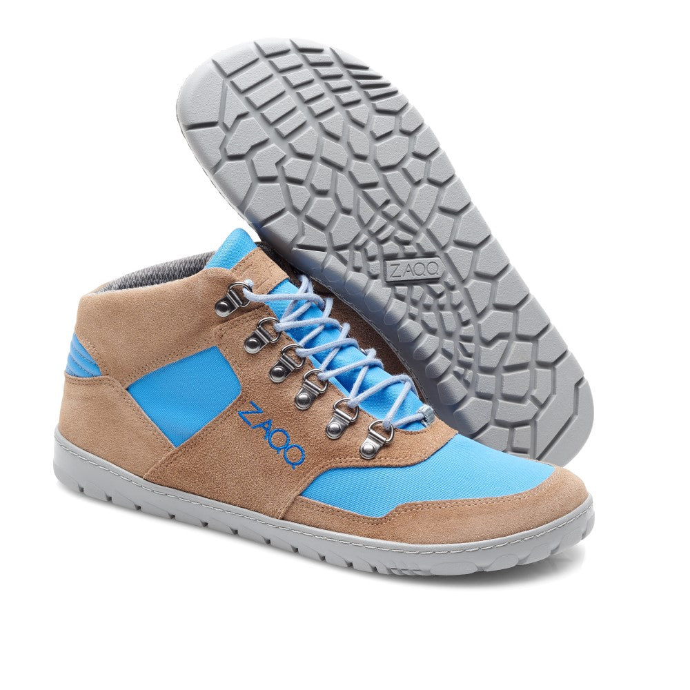 Wir präsentieren die wasserdichten HIQE Mid Sky-Sneaker von ZAQQ: Diese High-Top-Sneaker sind in einem Farbschema aus Blau und Braun erhältlich und erinnern an den Stil eines Outdoor-Stiefels. Sie verfügen über robuste graue Sohlen mit sechseckigem Profil, die sich ideal für den Halt auf rauen Oberflächen eignen. Das Design wird durch blaue Schnürsenkel und Metallösen vervollständigt und zeigt stolz den Markennamen ZAQQ an der Seite.