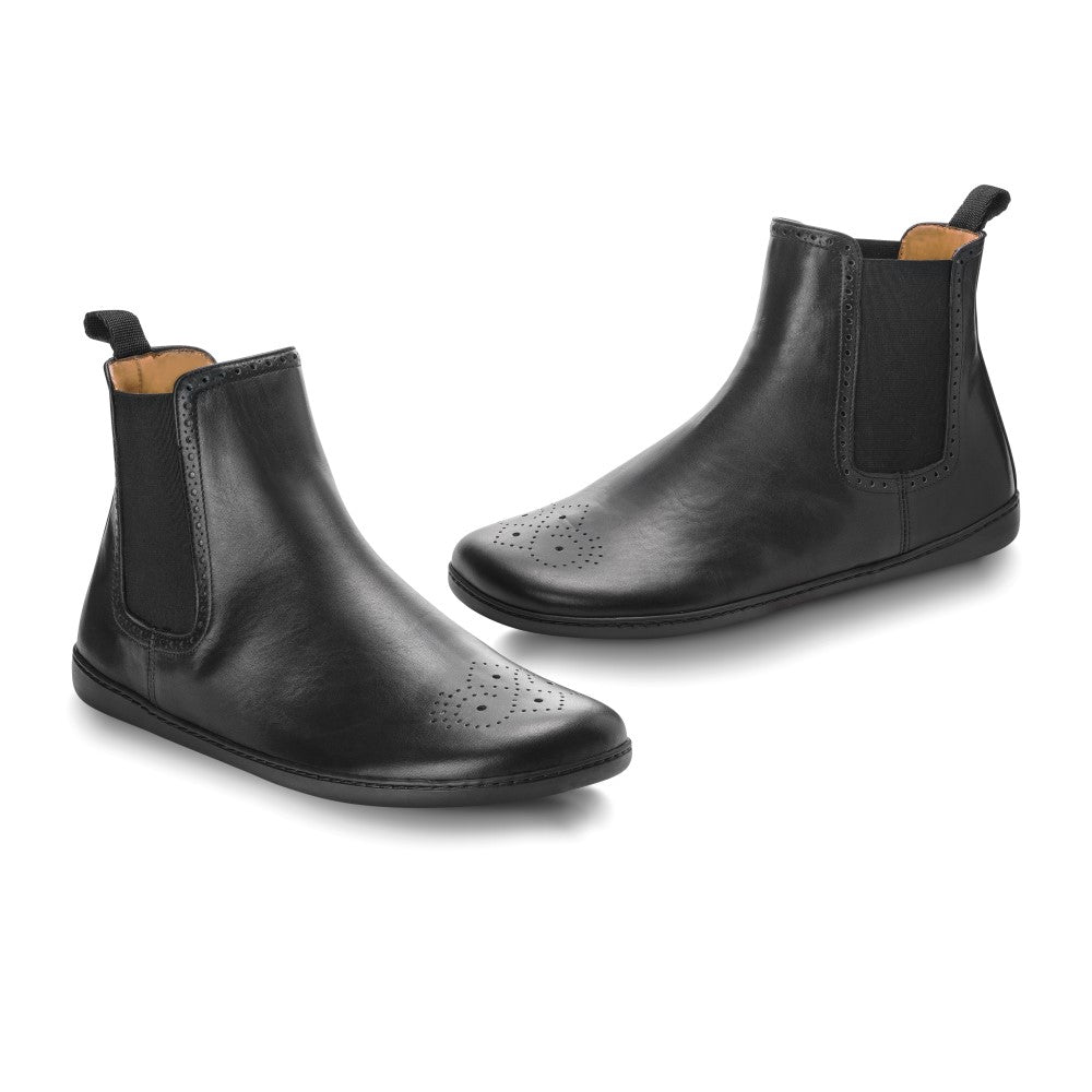 Ein Paar schwarze Chelsea-Stiefel EQUITY Brogue aus hochwertigem Nappaleder mit elastischen Seiteneinsätzen und Aufreißlaschen. Das Design von ZAQQ umfasst dezente dekorative Perforationen im Zehenbereich, wobei die Stiefel gekonnt aus verschiedenen Winkeln auf einem weißen Hintergrund präsentiert werden.