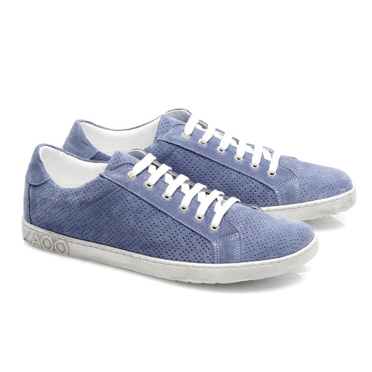 Die SLOQ Blue Sneaker von ZAQQ sind aus hellblauem Veloursleder gefertigt und verfügen über weiße Schnürsenkel sowie ein perforiertes Design. Die Sohlen weisen ein strukturiertes Muster auf, während das Logo der Marke elegant auf der Ferse eingeprägt ist und sich von einem makellos weißen Hintergrund abhebt.